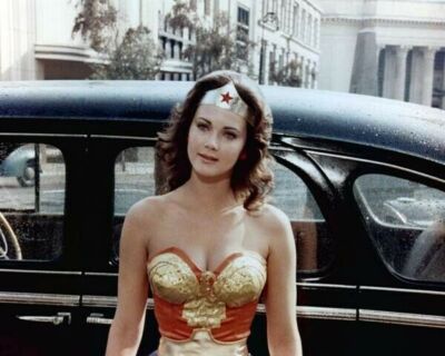 Lynda Carter busty as ever in Wonder Woman outfit standing by car poster 16x20