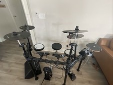 Donner DED-200 Drum set with amplifier, drumsticks, table, and seat.