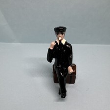 lead casting . Black clothes Man sitting on Trunks ; 