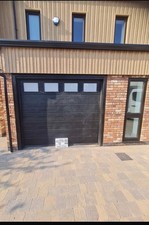 Insulated 40mm sectional garage door in black supplied and fitted with windows