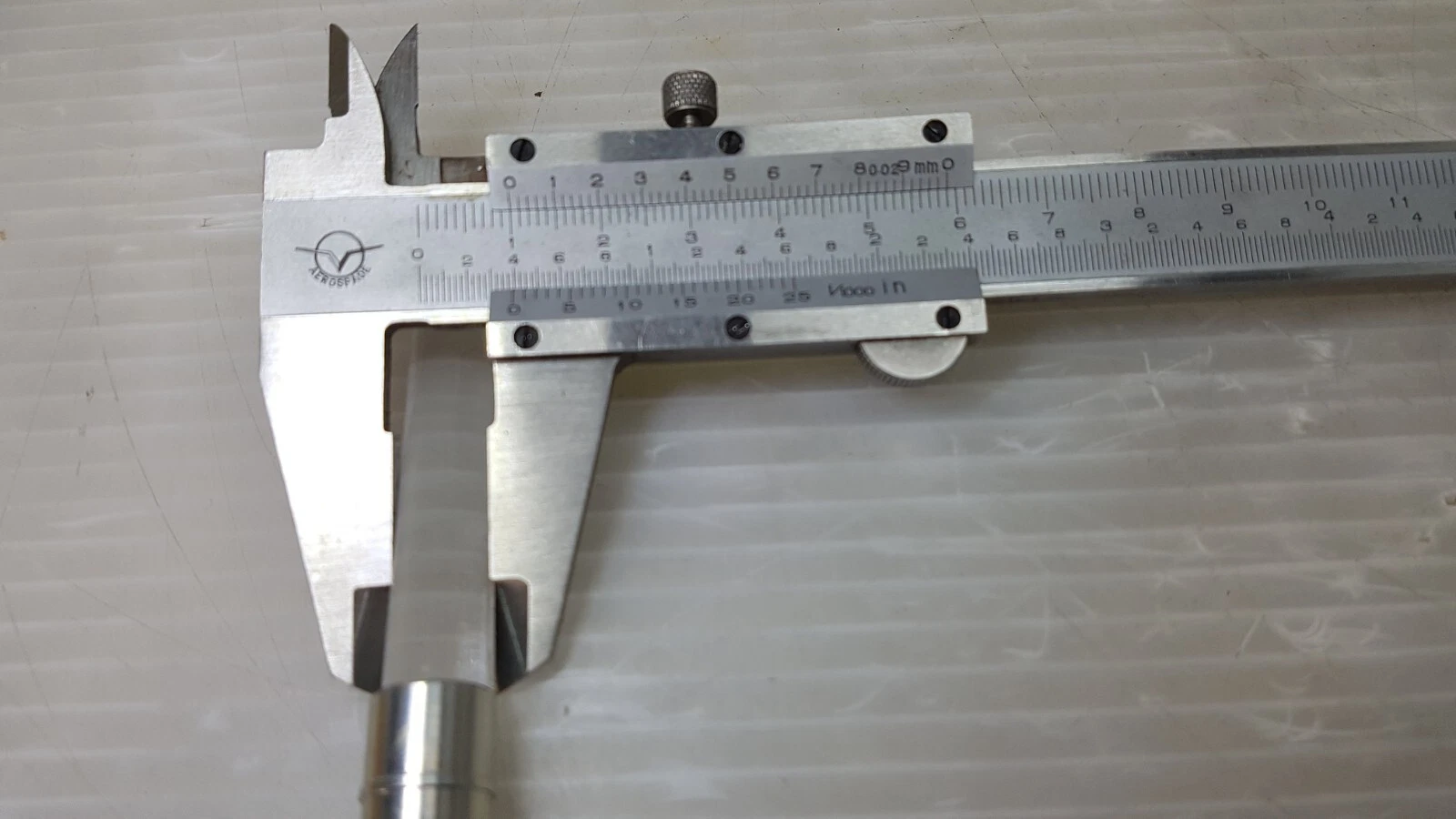 Caliper measuring the glass rod diameter at about 10 mm