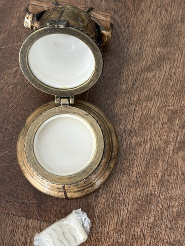 Two round gold Liberty Bell trinket boxes with white circular lids, hinged together by twisted gold rope detail.