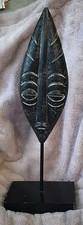vintage  hand-carved African tribal mask, displayed on a stand
