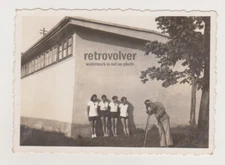 Four Beautiful Gymnasts Prepare for Photo Shoot with Photographer in the Frame