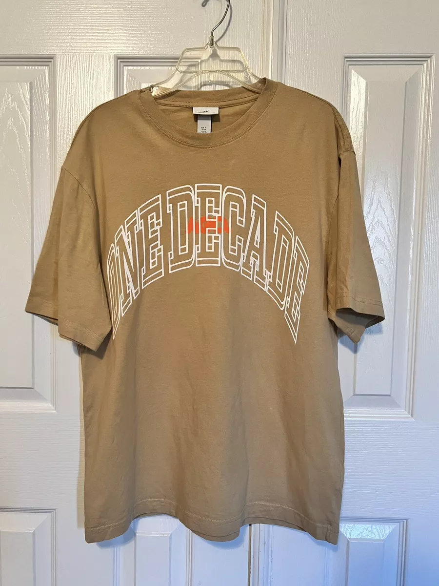 H M One Decade Men s Tan Brown Short Sleeve Graphic T Shirt Tee Medium