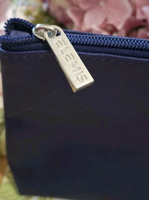 Kosmetiktasche der Marke Elemis tief lila mit silberfarbenen Akzenten