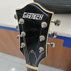 Black GRETSCH G5655T-QM hollow body electric guitar with silver hardware and four-piece tremolo, shown from the head.