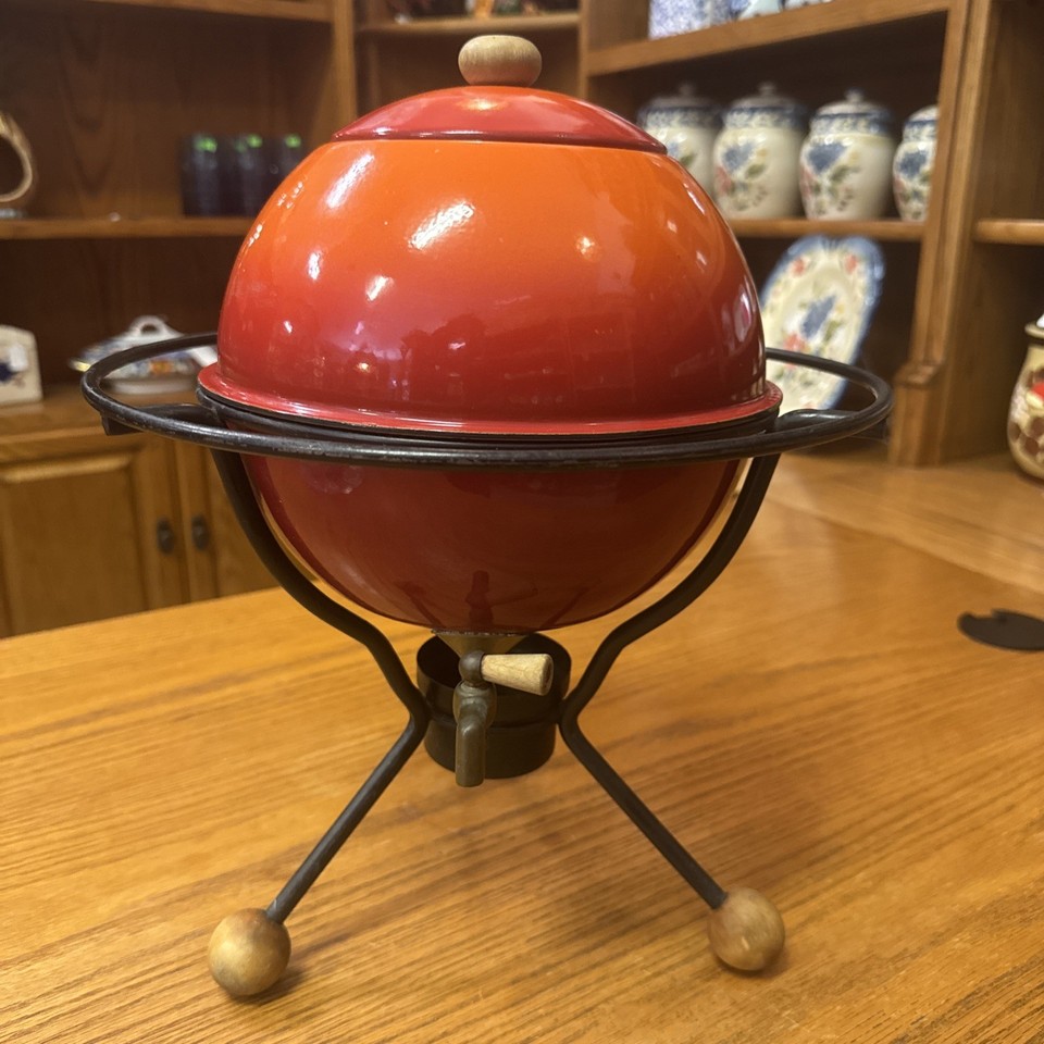 A bold red-orange enamelware beverage dispenser straight out of a 1960s backyard party — visually stunning and actually usable.