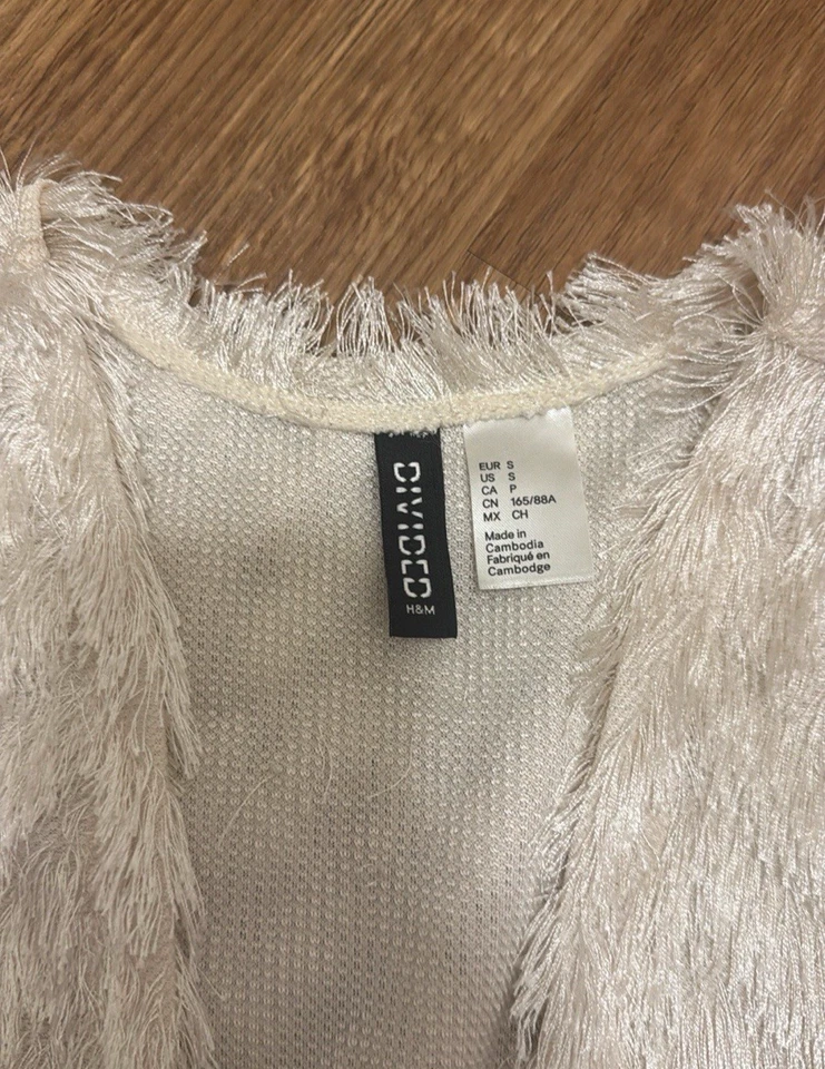 Suéter cárdigan abierto de piel peluda con flecos marfil pequeño dividido de H&M Foto 2 de 4