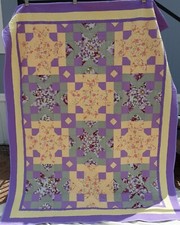 Handmade Purple, green and yellow quilt which measures approximately 82 by 66 in