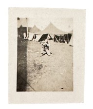 WW2 Era Photo U.S. GI Kneeling Holding Gun Base Camp Tents In Back