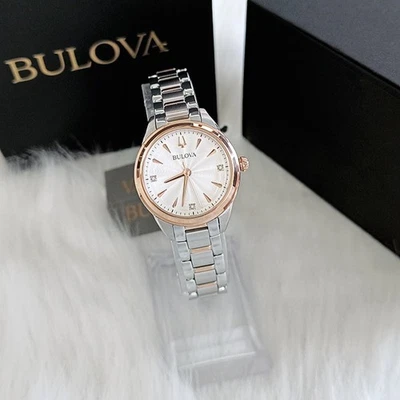 Reloj Bulova 98P200 Lady Sutton de plata y oro rosa con bisel de cristal, presentado sobre terciopelo negro en una caja de la marca.