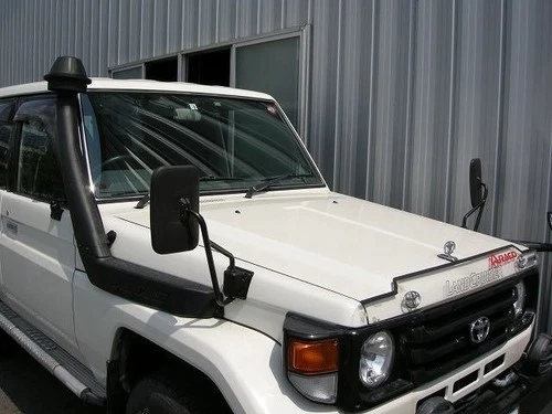 White Toyota 70 Series Land Cruiser with black roof snorkel, side mirror, and Toyota Land Cruiser logo on front grille.