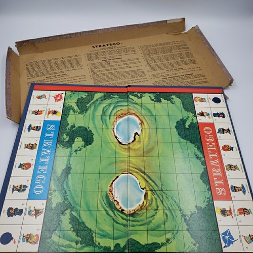 Vintage 1961 Stratego board with green-bordered game board, box, and instructions in red folder on wood surface.