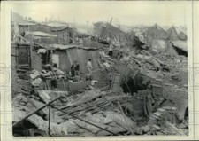 Foto de prensa 1970 sobrevivientes tropiezan con escombros de edificios, Chimbote, Perú