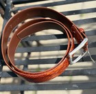 Brown leather belt with silver buckle, dual loops, and visible “Made in U.S.A.” text on black metal plate.