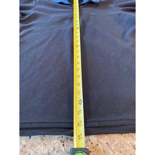 Black quarter zip fleece pullover with long sleeves, shown on a surface with a yellow measuring tape.