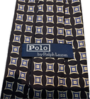 Navy silk tie with white geometric diamond pattern, blue and white labels reading “Polo by Ralph Lauren.”