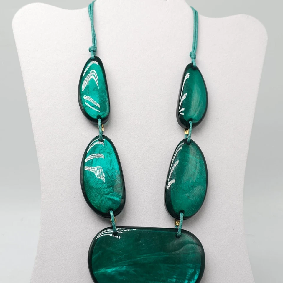 Collar artesanal de resina verde con cordón ajustable y detalles en tono dorado Foto 3 de 4