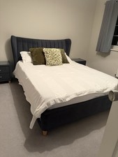 Upholstered bed frame with winged headboard, plus two matching bedside tables