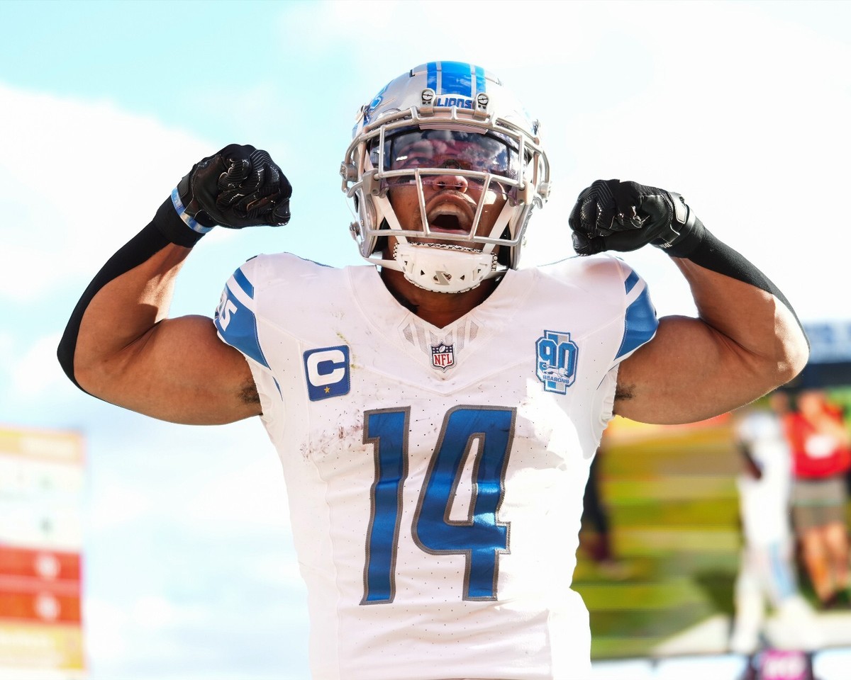Amon-Ra St Brown Flexing on Field Detroit Lions 8x10 NFL Football Photo
