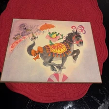 1967 George Buckett Print on Pressboard: Dancing Frog On A Horse.
