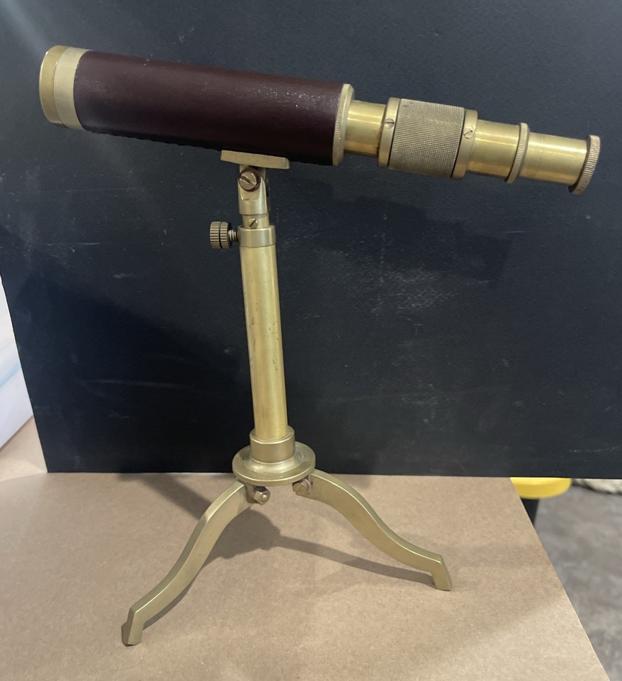 A tabletop brass telescope on a proper stand with leather wrapping — looks like it belongs in a Victorian captain's study.