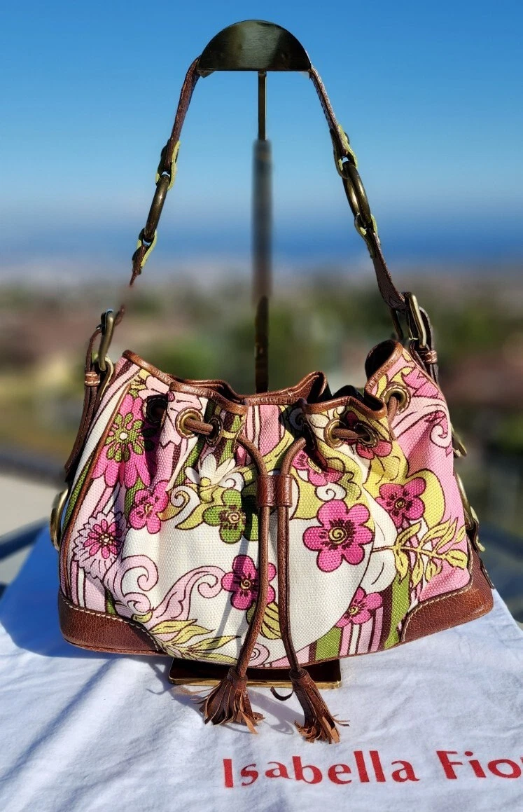 Woman holding brown and pink floral leather crossbody bag photo