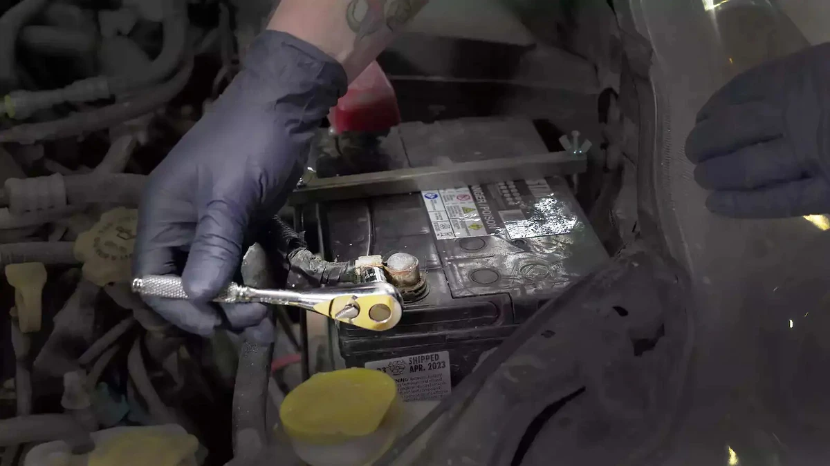 Removing the battery negative clamp with a socket wrench.