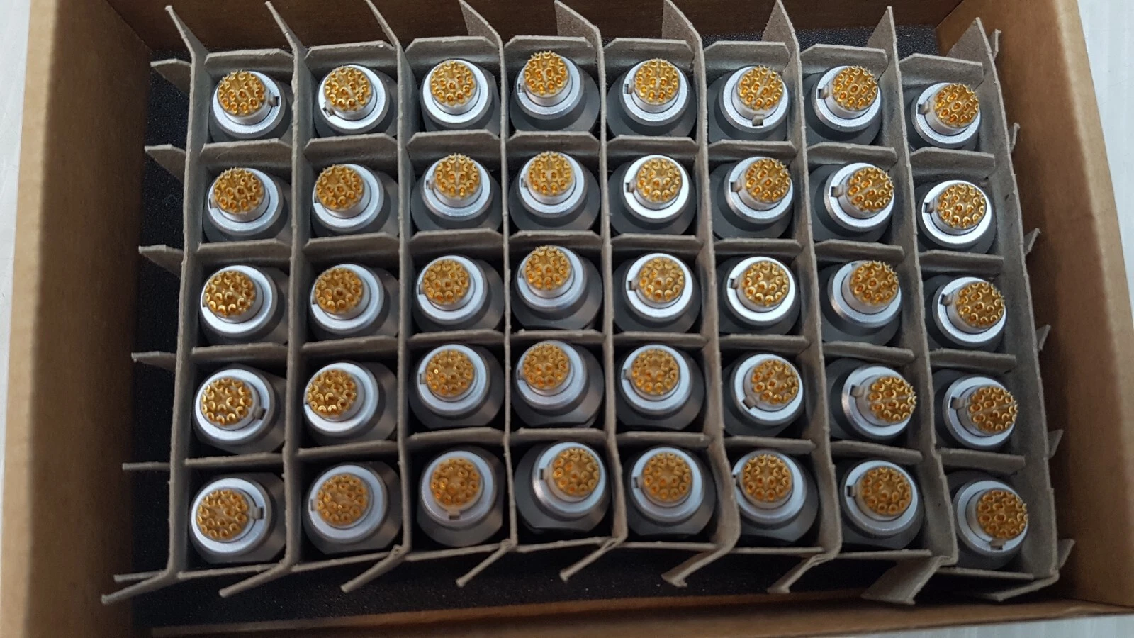 Forty ODU GK2LCC-P18LFG0-02F0 receptacles standing in a cardboard divider tray