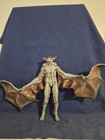 Gray-bat Man-Bat DC Collectibles figure with brown wings and bat-like limbs on a blue fabric background.