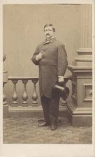 CDV PORTRAIT OF WELL-DRESSED PLUMP MAN HOLDING TOP HAT W/ POSING STAND