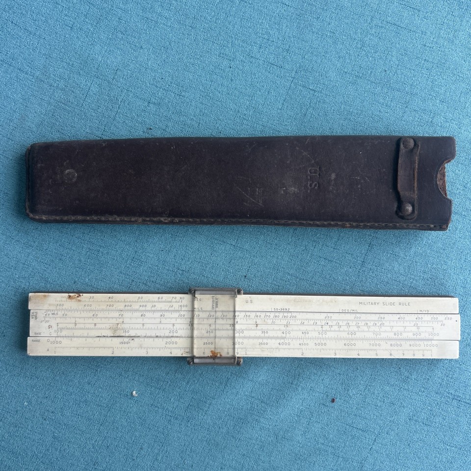 A genuine WWII-era military artillery slide rule — not a toy, an actual tool used to calculate shell trajectories in the field.