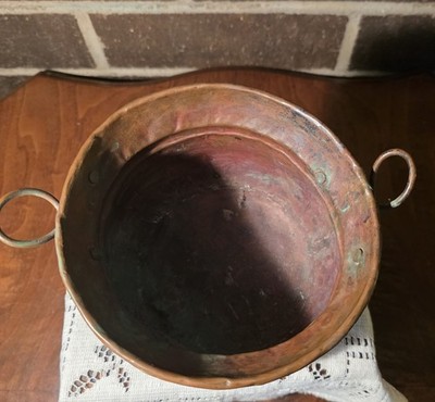 antique copper cauldron with handles.