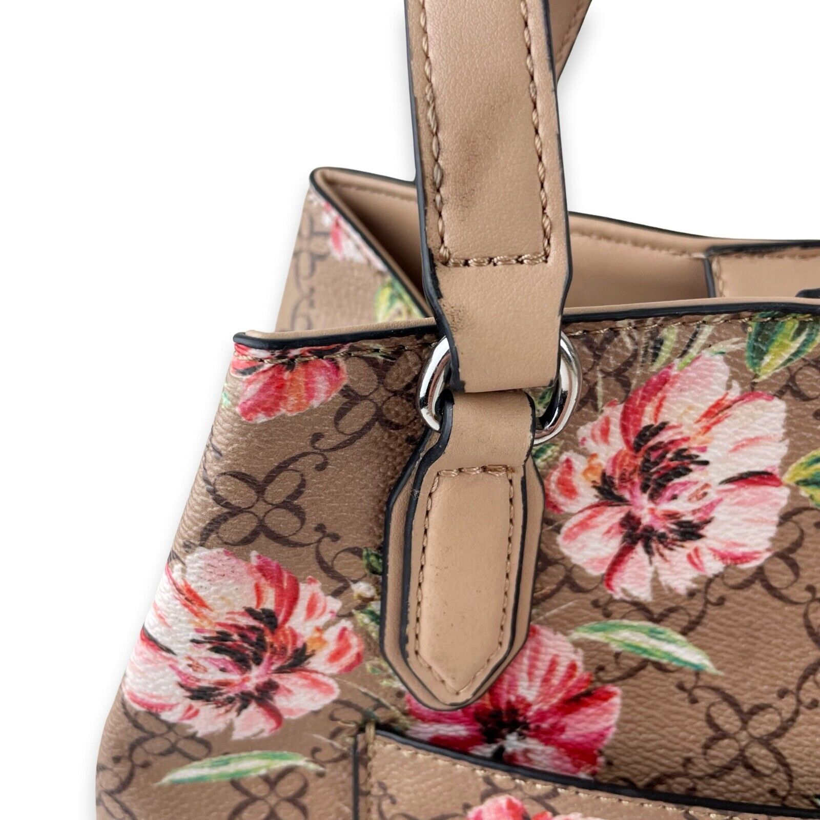 Woman holding brown and pink floral leather crossbody bag photo