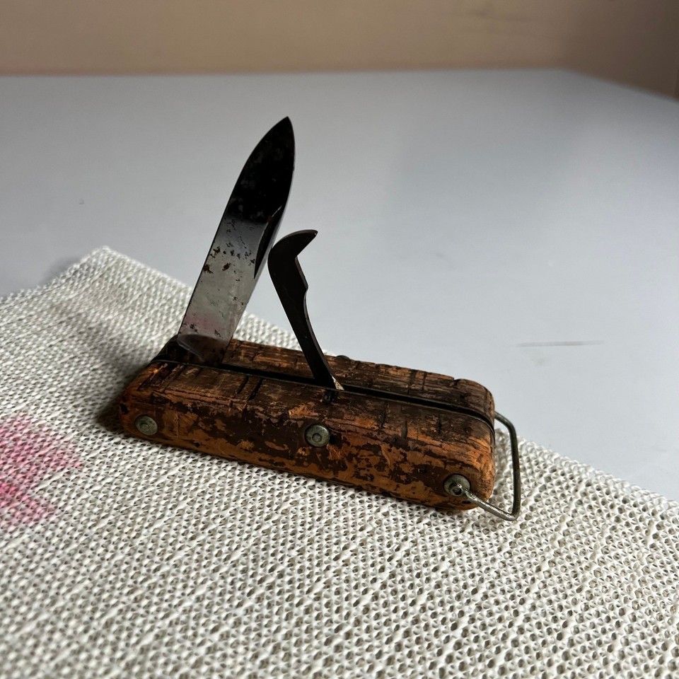 A Neiman Marcus-branded Italian folding multi-tool with a cork handle — luxury department store provenance meets old-world Italian craftsmanship in a pocket-sized package.