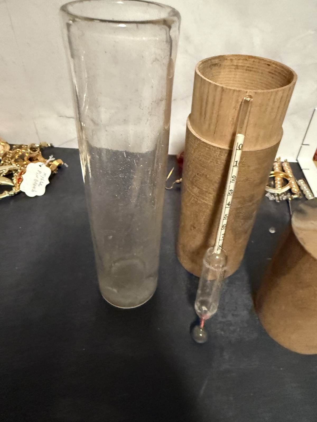 A clear glass test jar & alcohol hydrometer used to measure the proof of liquid