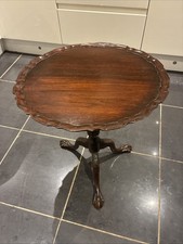 A mahogany Chippendale-style tilt-top pie crust table with ball-and-claw feet.