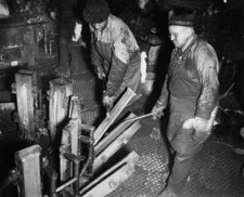 Two foundry workers removing cast ingots from molds, one stage pro Old Photo