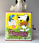 Yellow Snoopy-themed Mattel box with blue cap, featuring Snoopy in a red box playing a guitar under a blue sky and flowers.