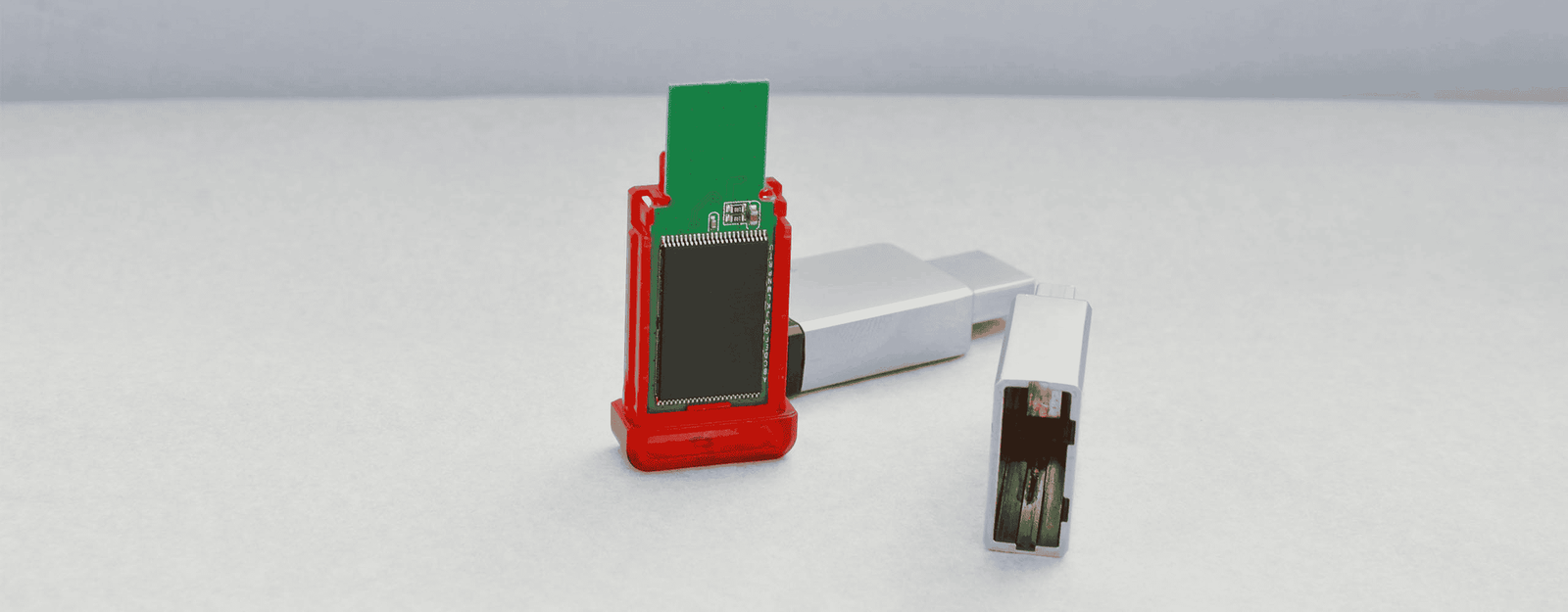Das Innenleben eines USB-Sticks in Rot und Grün auf grauem Hintergrund