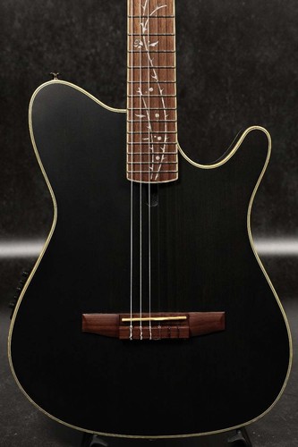 Black Ibanez TOD10N transparent flat guitar with gold hardware, five-pickup neck, and subtle floral leaf pattern on fretboard.