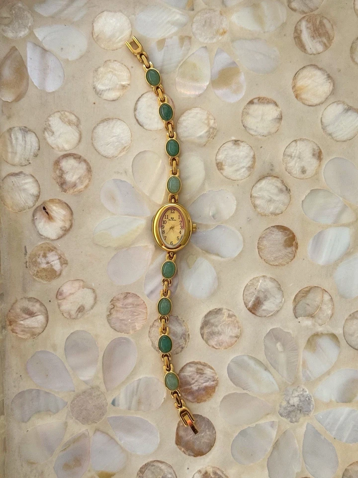 Reloj estilo vintage tono dorado con correa de piedras preciosas verdes y cara ovalada Foto 3 de 4