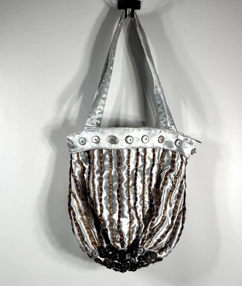 Cartera artesanal de satén plateada con adornos de botones y cuentas Foto 3 de 4