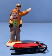 VTG Christmas Village 2” figurine Tiny Tim? Man Carrying Boy & sled porcelain