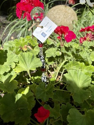 Decorative beaded flower stake with added cross charm And ceramic Topper