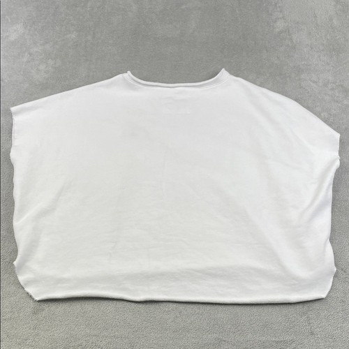 White 100% cotton funnel neck capelet with long sleeves, made in USA, displayed flat on a textured gray surface.
