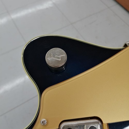 Black and gold GRETSCH G5655T-QM hollow body electric guitar with silver hardware and engraved brand logo on head.