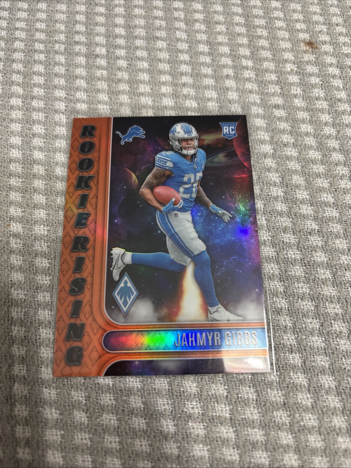 2023 Panini Phoenix - Rookie Rising Jahmyr Gibbs #RIS-8 Orange /99 (RC)