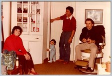 Gruppo famiglia snapshot a colori vintage in soggiorno con sedia da barbiere vintage anni 90